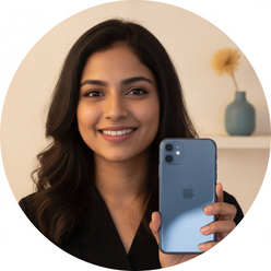 Circular portrait of a smiling young Indian woman, Anjali Singh, holding an iPhone 11 against a warm cream background.