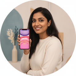 Portrait of Kavya Nair, a South Asian woman, smiling and holding an iPhone 11, against a clean background.